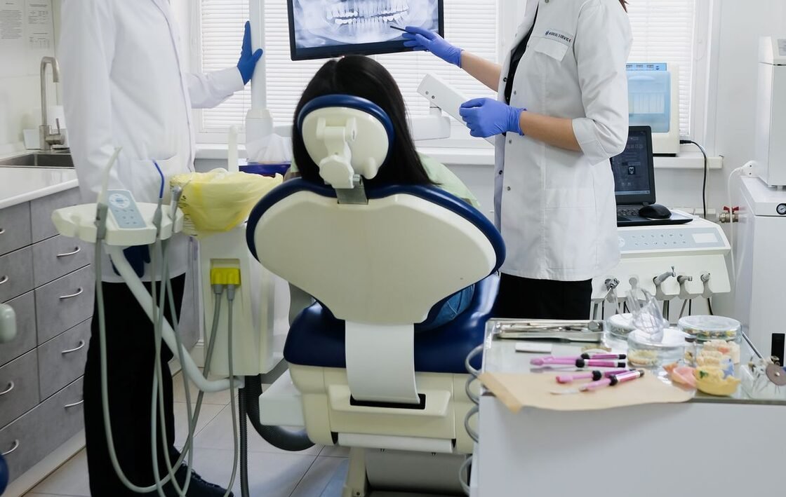Equipo de una clínica dental trabajando con automatización de apoyo junto al sillón